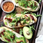 A new take on traditional avocado toast - theses Vegan Cream Cheese Avocado Flatbreads are layered with cream cheese, sun-dried tomatoes, avocado slices and arugula | ThisSavoryVegan.com #vegan #avocadotoast