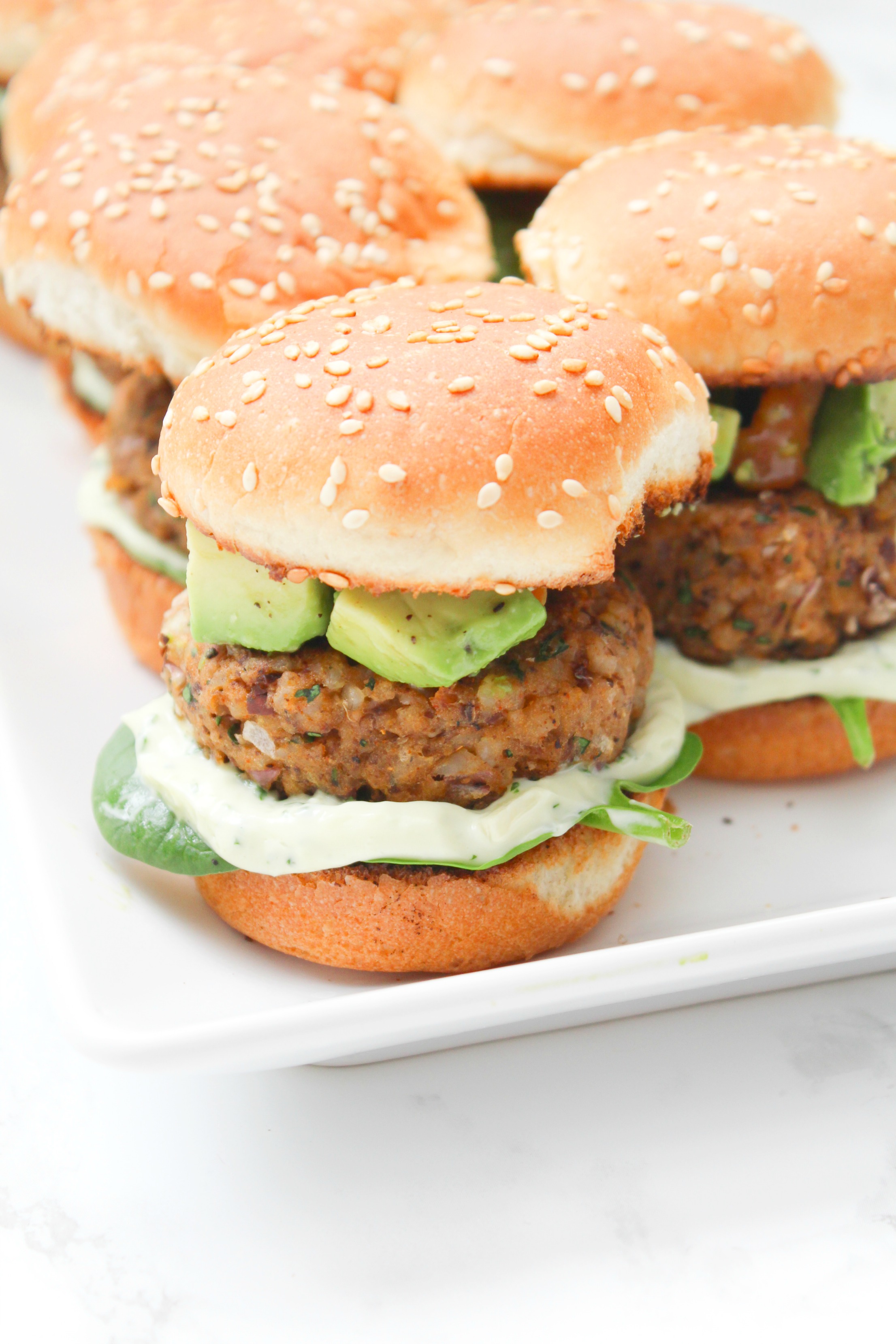 These Zesty Brown Rice Black Bean Vegan Sliders with Basil Aioli are the perfect party appetizer. Topped off with an avocado & tomato salsa | ThisSavoryVegan.com #thissavoryvegan #vegan #sliders