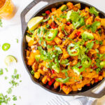 Get ready for your next party with these Potato Soyrizo Skillet Nachos with Chipotle Cilantro Sauce. Loaded with black beans, veggies and vegan sausage | ThisSavoryVegan.com #thissavoryvegan #vegannachos #vegangamedaysnacks
