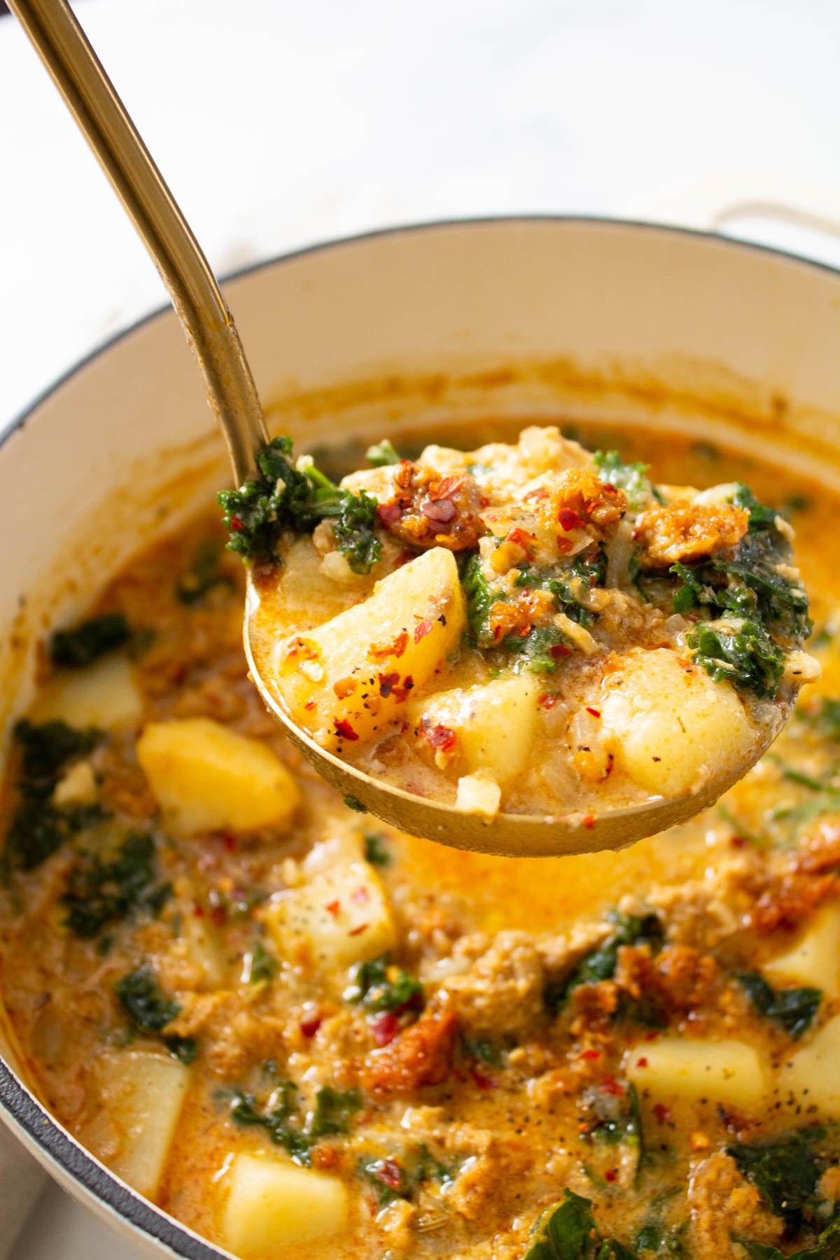 This Vegan Zuppa Toscana soup is perfectly creamy and comforting. Potatoes, vegan sausage and kale are loaded up in a super flavorful broth | ThisSavoryVegan.com #thissavoryvegan #vegansoup #zuppatoscana