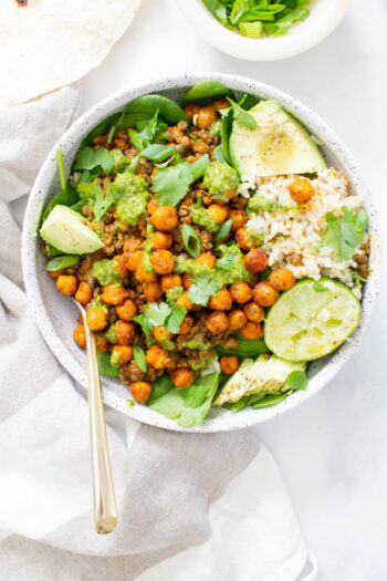 These Chickpea Lentil Taco Rice Bowls are filled with brown rice, spinach, roasted chickpeas & vegan taco lentil meat. All topped off with chimichurri | ThisSavoryVegan.com #thissavoryvegan #veganrecipe #vegantacobowl