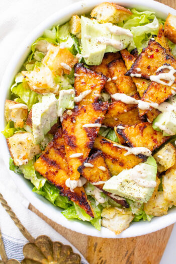 This Grilled Tempeh Vegan Caesar Salad is lightened up by using a tahini-based dressing and protein-packed with marinated tempeh | ThisSavoryVegan.com #thissavoryvegan #vegancaesar #salad