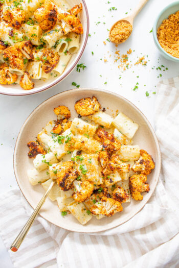 This Creamy Vegan Rigatoni with Roasted Cauliflower is made with a simple and delicious cream sauce, plenty of fresh herbs, and crispy roasted cauliflower. A tasty vegan dinner that is a crowd pleaser | ThisSavoryVegan.com #thissavoryvegan #veganpasta #vegandinner
