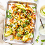 These Vegan Breakfast Nachos are loaded with air fryer chips, vegan eggs, refried beans, soyrizo, veggies and vegan cilantro ranch. Perfect for brunch at home | ThisSavoryVegan.com #thissavoryvegan #veganbrunch #vegannachos
