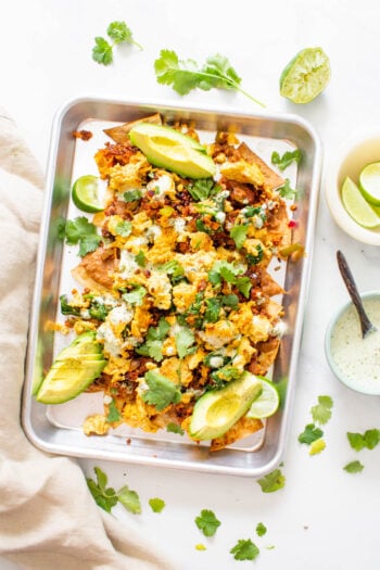 These Vegan Breakfast Nachos are loaded with air fryer chips, vegan eggs, refried beans, soyrizo, veggies and vegan cilantro ranch. Perfect for brunch at home | ThisSavoryVegan.com #thissavoryvegan #veganbrunch #vegannachos