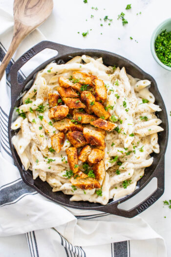 This Vegan Chicken Alfredo Pasta is the ultimate comfort meal! The sauce is lightened up by using a cauliflower base and the chicken is smoky and flavor-packed | ThisSavoryVegan.com #thissavoryvegan #veganalfredo #veganpasta