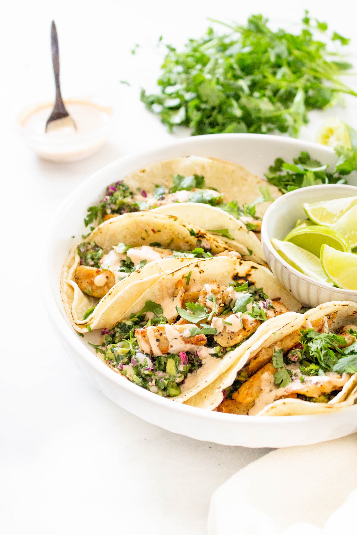 These Vegan Lemon Pepper Chicken Tacos are loaded with a kale avocado slaw and a chili lime crema. Perfect for your next Taco Tuesday | ThisSavoryVegan.com #thissavoryvegan #vegantacos #lemonpepperchicken