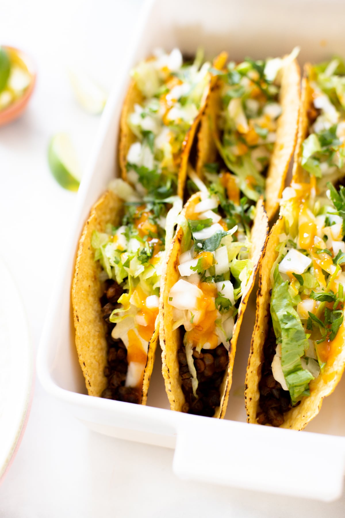 These Vegan Oven Baked Tacos are the perfect weeknight dinner. Crispy taco shells are loaded with lentil taco "meat" and vegan queso | ThisSavoryVegan.com #thissavoryvegan #vegantacos #tacocasserole