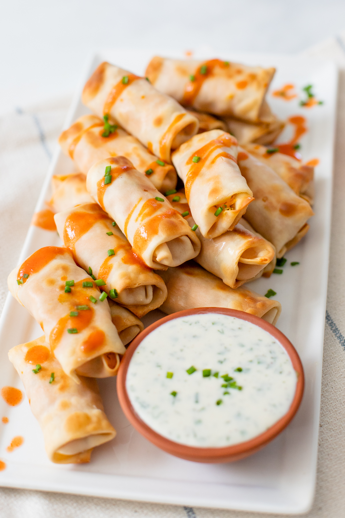 These Vegan Buffalo Chicken Mini Egg Rolls are the perfect party snack. These bite-sized appetizers are served with vegan ranch & extra hot sauce | ThisSavoryVegan.com #thissavoryvegan #veganeggrolls #gamedaysnacks