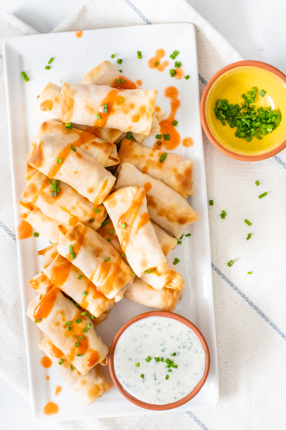 These Vegan Buffalo Chicken Mini Egg Rolls are the perfect party snack. These bite-sized appetizers are served with vegan ranch & extra hot sauce | ThisSavoryVegan.com #thissavoryvegan #veganeggrolls #gamedaysnacks