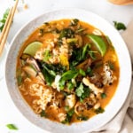 This Vegan Thai Peanut Ramen is packed with flavor and loaded up with noodles, crispy cauliflower, roasted shallots and tons of fresh toppings | ThisSavoryVegan.com #thissavoryvegan #veganramen #thairamen