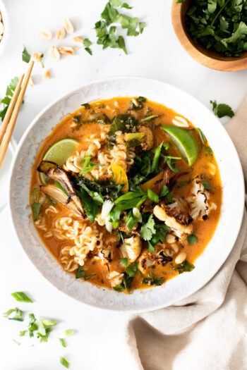 This Vegan Thai Peanut Ramen is packed with flavor and loaded up with noodles, crispy cauliflower, roasted shallots and tons of fresh toppings | ThisSavoryVegan.com #thissavoryvegan #veganramen #thairamen