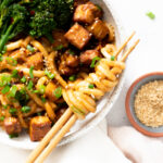These Spicy Peanut Udon Noodle Bowls are loaded with crispy baked tofu, broccolini and saucy noods. A savory and healthy vegan dinner | ThisSavoryVegan.com #thissavoryvegan #tofunoodlebowls #vegandinnerideas