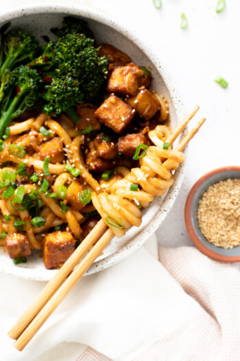 These Spicy Peanut Udon Noodle Bowls are loaded with crispy baked tofu, broccolini and saucy noods. A savory and healthy vegan dinner | ThisSavoryVegan.com #thissavoryvegan #tofunoodlebowls #vegandinnerideas