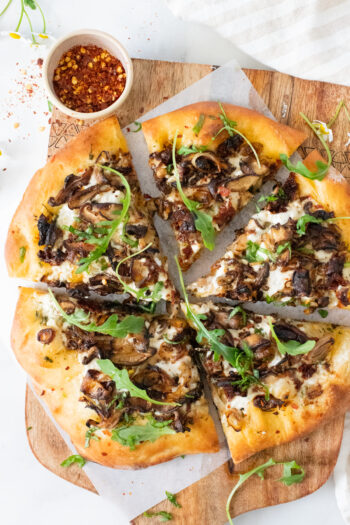 This Vegan Mushroom & Shallot White Pizza is better than takeout! Plenty of herbs, sun-dried tomatoes, creamy sauce & caramelized mushrooms | ThisSavoryVegan.com #thissavoryvegan #veganpizza #veganwhitepizza