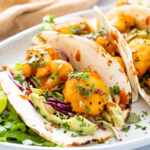 These Vegan Bang Bang Cauliflower Tacos are slightly spicy and a whole lotta delicious! A tangy slaw, crispy cauliflower and avocado slices | ThisSavoryVegan.com #thissavoryvegan #vegantacos #cauliflowertacos