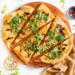 This Everything But the Bagel Vegan Flatbread is made with sun-dried tomatoes, shallots and a white sauce. Topped off with arugula & basil | ThisSavoryVegan.com