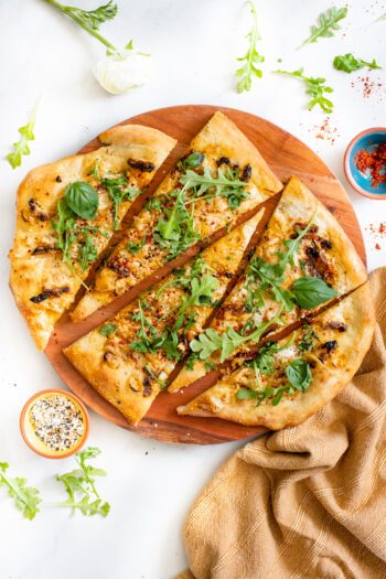 This Everything But the Bagel Vegan Flatbread is made with sun-dried tomatoes, shallots and a white sauce. Topped off with arugula & basil | ThisSavoryVegan.com