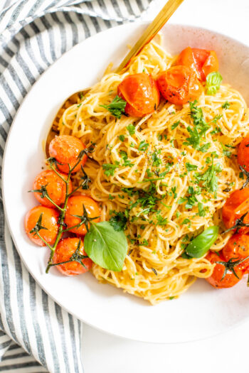 This Creamy Vegan Garlic Pasta has a simple sauce and is topped with burst tomatoes on the vine. A quick & delicious vegan dinner idea | ThisSavoryVegan.com #thissavoryvegan #veganpasta #summerpasta