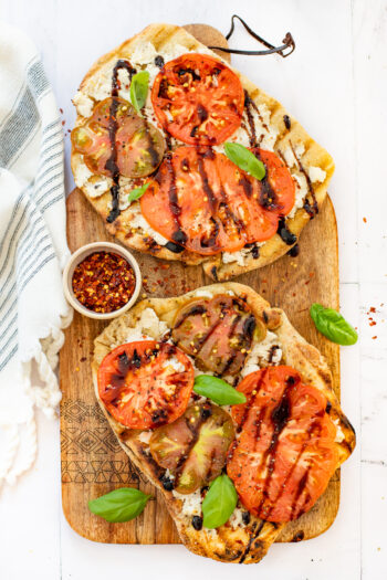This Grilled Heirloom Tomato Pizza is layered with vegan ricotta, thick slices of heirloom tomatoes, balsamic glaze & fresh basil | ThisSavoryVegan.com #thissavoryvegan #veganpizza #grilledpizza