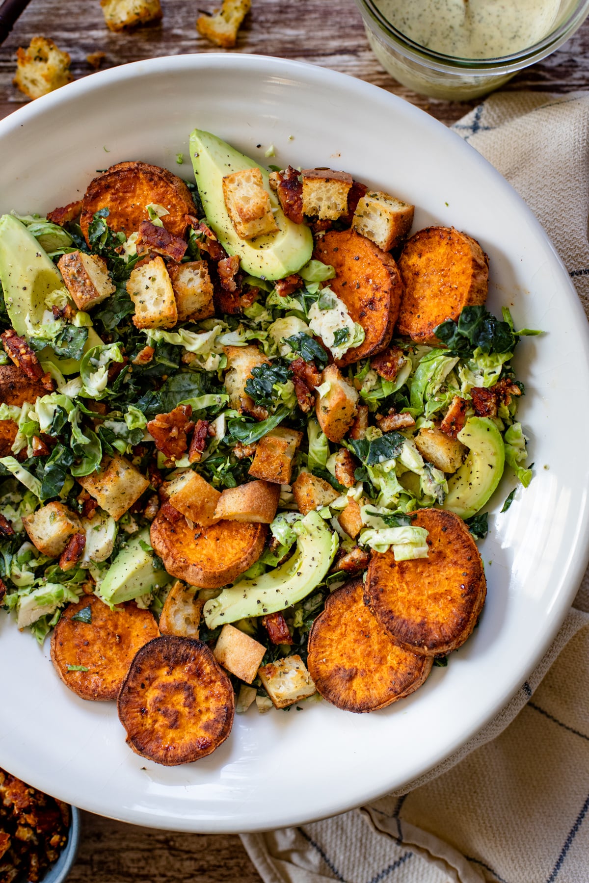 This Brussels & Kale Vegan Caesar is loaded with sweet potatoes, tempeh bacon, homemade croutons, avocado and the BEST caesar dressing | ThisSavoryVegan.com #vegancaesar #fallsalads #falldinnerideas