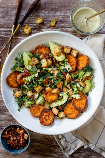 This Brussels & Kale Vegan Caesar is loaded with sweet potatoes, tempeh bacon, homemade croutons, avocado and the BEST caesar dressing | ThisSavoryVegan.com #vegancaesar #fallsalads #falldinnerideas