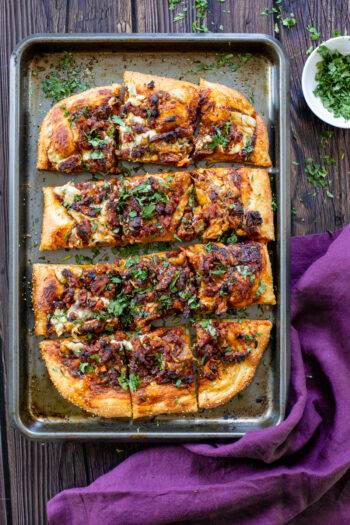 This Vegan BBQ Bacon Pizza is better than any take-out I've had and a great dinner to make on a Friday at home. Layered with caramelized onions, tempeh bacon and a creamy sauce | ThisSavoryVegan.com #thissavoryvegan #veganpizza #plantbasedpizza