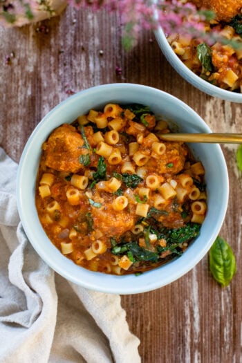 This Vegan Meatball Soup with Pasta & Kale is a hearty and satisfying dinner recipe. Simmered in a flavorful pesto broth | ThisSavoryVegan.com #thissavoryvegan #vegansoup #veganfallrecipes