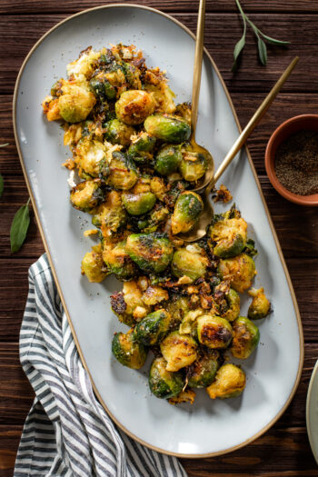 These Crispy Vegan Smashed Brussels Sprouts are boiled, smashed, then roasted until crispy and delicious. Made with shallots and vegan parmesan | ThisSavoryVegan.com #thissavoryvegan #smashedbrusselssprouts #veganthanksgiving