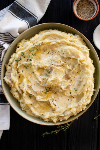 Set it and forget it - these Slow Cooker Vegan Mashed Potatoes are the perfect make ahead holiday side dish. Garlic, herbs and non-dairy cream | ThisSavoryVegan.com #thissavoryvegan #veganthanksgiving #veganmashedpotatoes