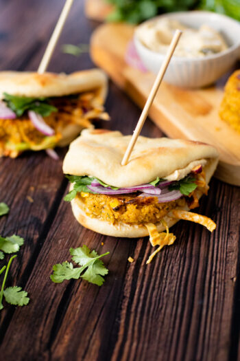 These Red Curry Chickpea Burgers with Tahini Slaw have a crispy burger, crunchy slaw & creamy hummus, all served on a piece of warm naan | ThisSavoryVegan.com #thissavoryvegan #veganburger #veggieburger