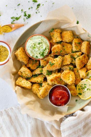 These Lemon Pepper Tofu Nuggets with Green Tahini Sauce are the perfect snack or addition to a salad or bowl. Breaded and baked until crispy | ThisSavoryVegan.com #thissavoryvegan #tofunuggets #vegansnacks