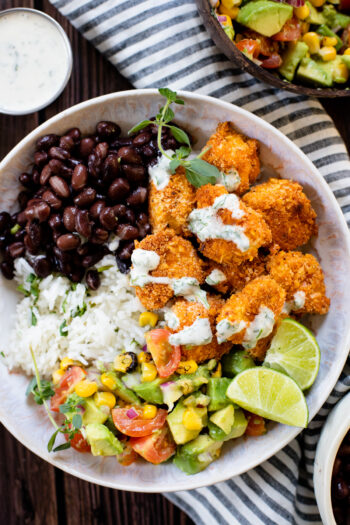 These Coconut Cajun Tofu Bowls are filled with crispy baked tofu, cilantro lime rice, black beans, avocado salsa and a creamy vegan cilantro sauce | ThisSavoryVegan.com #thissavoryvegan #tofubowls #vegandinnerideas