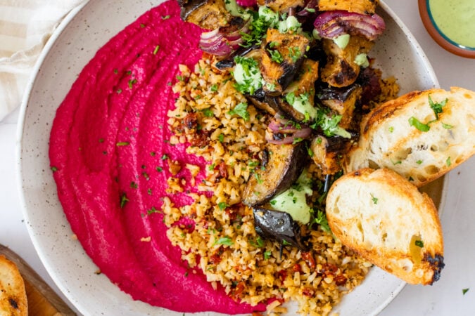 These Grilled Eggplant Skewer Bowls are filled with mediterranean cauliflower rice, roasted beet hummus and a basil aioli - seriously tasty | ThisSavoryVegan.com #thissavoryvegan #veganbowls #hummusbowls