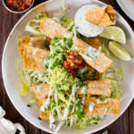 These Green Chile Chickpea Taquitos have a creamy vegan chickpea filling and are served up with vegan jalapeño ranch for dipping | ThisSavoryVegan.com #thissavoryvegan #veganrolledtacos #vegantaquitos