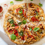 This Vegan Spicy Chicken Pizza is layered with homemade vegan cheese, seasoned soy curls, sun-dried tomatoes and plenty of peppers | ThisSavoryVegan.com #thissavoryvegan #veganpizza #plantbasedpizza