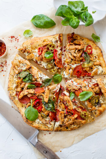 This Vegan Spicy Chicken Pizza is layered with homemade vegan cheese, seasoned soy curls, sun-dried tomatoes and plenty of peppers | ThisSavoryVegan.com #thissavoryvegan #veganpizza #plantbasedpizza
