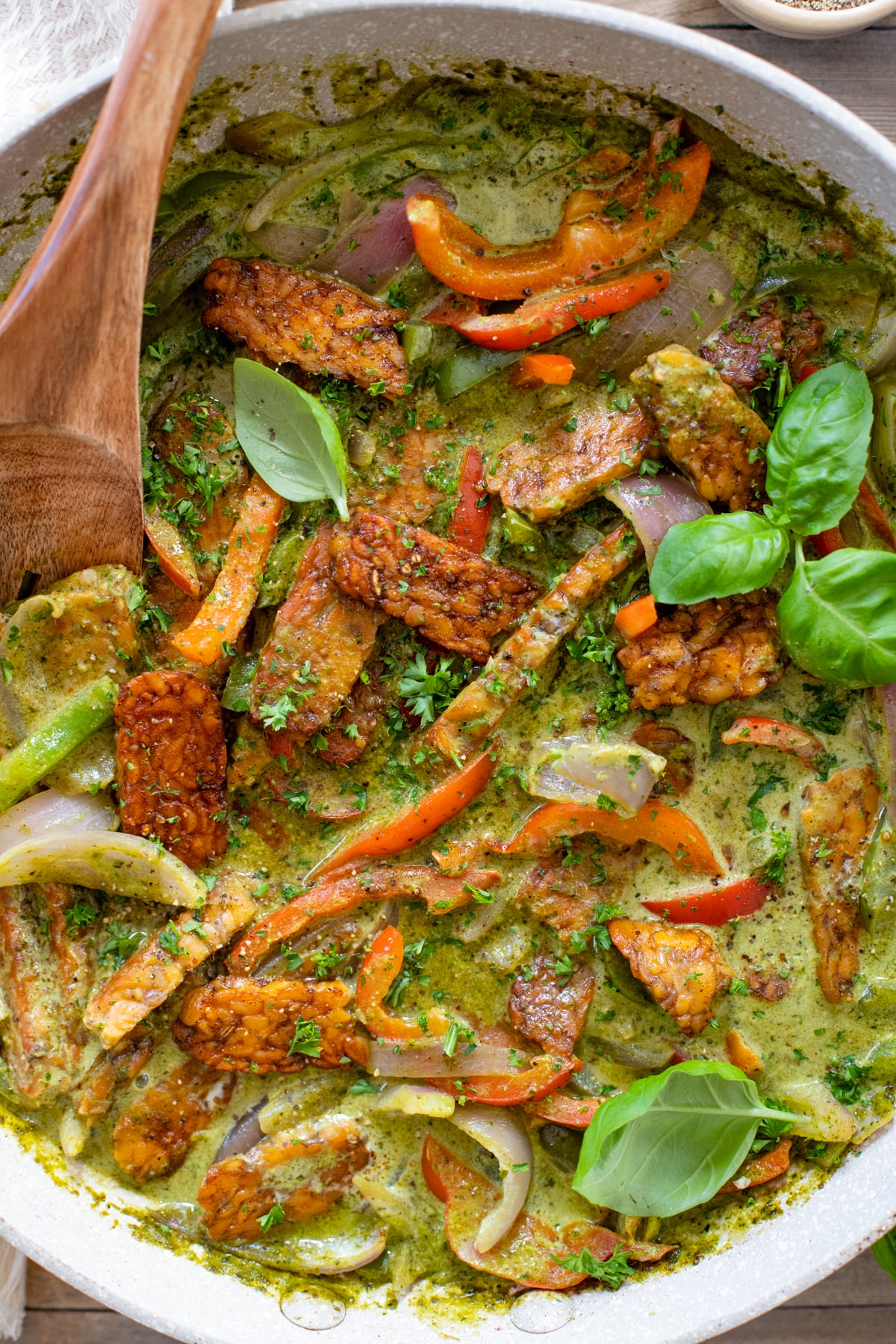 Tempeh & Peppers in Pesto Cream Sauce is a super easy and delicious vegan dinner idea! Served over rice and topped with plenty of fresh basil | ThisSavoryVegan.com #thissavoryvegan #tempehrecipes #skilletdinner