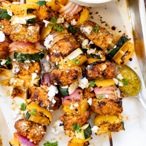 These Greek Tempeh Skewer Bowls are the perfect summer meal! Marinated tempeh is grilled until crispy & served with vegan feta dressing and herbed rice | ThisSavoryVegan