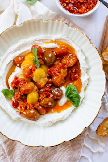 This Vegan Whipped Feta Dip is BEYOND addicting! The whipped dip is topped with oven roasted tomatoes and Calabrian chili paste for a little kick | ThisSavoryVegan.com #thissavoryvegan #veganfeta #veganappetizers