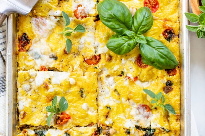 This Sheet Pan Vegan Frittata is made with all of your favorite mediterranean flavors -vegan feta, sautéed tomatoes, sun-dried tomatoes & basil | ThisSavoryVegan.com #thissavoryvegan #veganbreakfast #veganbrunch