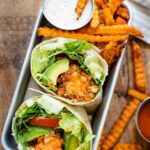 These Vegan Buffalo Sriracha Chicken Wraps are the perfect on the go lunch. Soy curl chicken wings, non-dairy caesar dressing, avocado and veggies | ThisSavoryVegan.com #thissavoryvegan #veganchicken #veganwrapideas