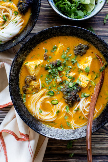 This Butternut Squash Curry Noodle Soup has a coconut & red curry base and is filled with roasted purple cauliflower, tofu and rice noodles | ThisSavoryVegan.com #thissavoryvegan #vegancurry #vegannoodlesoup