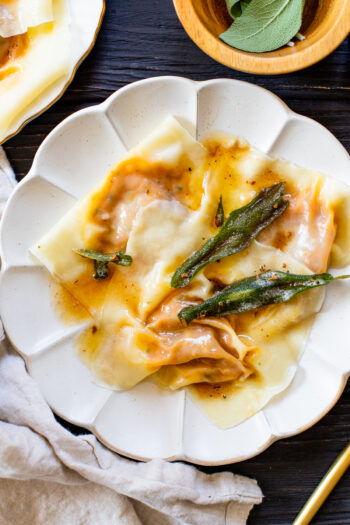 These Vegan Pumpkin Wonton Ravioli are the perfect Fall dinner. Made simple by using wonton wrappers and served up with a brown butter sage sauce | ThisSavoryVegan.com #thissavoryvegan #pumpkinravioli #veganravioli #wontonravioli