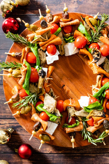 This Christmas Antipasto Wreath is the perfect holiday appetizer! Loaded with vegan cheese, vegan pepperoni, olives, artichoke hearts & basil | ThisSavoryVegan.com #thissavoryvegan #christmasrecipes #holidayappetizers