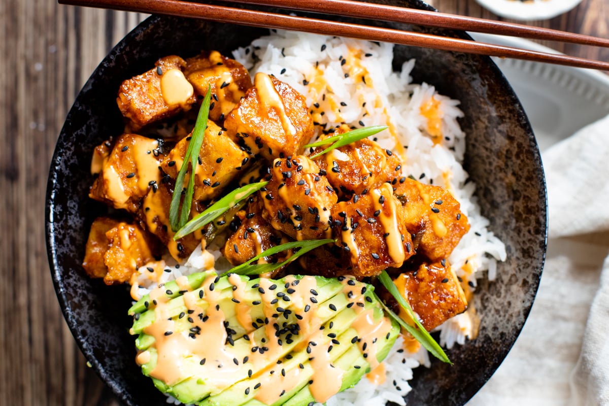 These Maple Sriracha Tofu Bowls have the perfect amount of sweetness & spice. Served over rice with spicy mayo & sesame seeds | ThisSavoryVegan.com #thissavoryvegan #tofubowls #vegandinnerideas