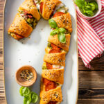 This vegan Candy Cane Pizza Crescent is a super fun Christmas recipe. Load it up with your favorite pizza toppings, bake and eat | ThisSavoryVegan.com #thissavoryvegan #christmasrecipes #christmasappetizer