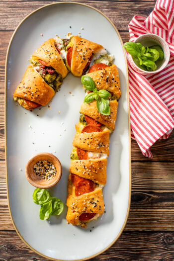 This vegan Candy Cane Pizza Crescent is a super fun Christmas recipe. Load it up with your favorite pizza toppings, bake and eat | ThisSavoryVegan.com #thissavoryvegan #christmasrecipes #christmasappetizer