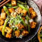 Hoisin Tofu Rice Bowls are a mix of crispy tofu, snap peas, rice and a delicious homemade sauce. The perfect plant based tofu bowl | ThisSavoryVegan.com #thissavoryvegan #tofurecipes #tofubowl