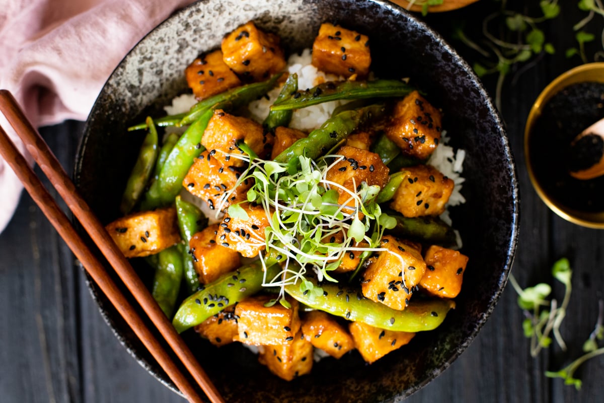 Hoisin Tofu Rice Bowls are a mix of crispy tofu, snap peas, rice and a delicious homemade sauce. The perfect plant based tofu bowl | ThisSavoryVegan.com #thissavoryvegan #tofurecipes #tofubowl